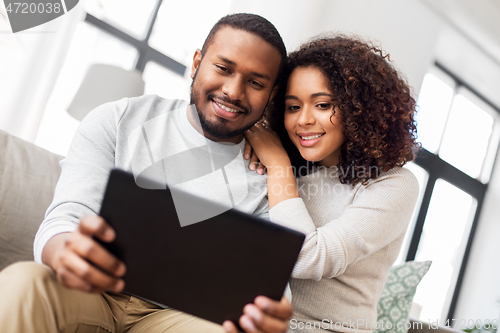 Image of african american couple with tablet pc at home