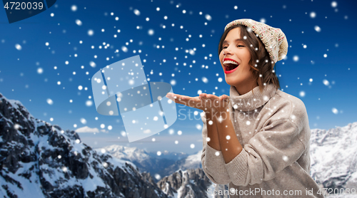 Image of young woman in knitted winter hat in mountains