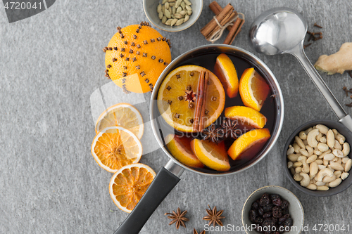 Image of pot with hot mulled wine, orange slices and spices