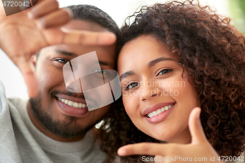 Image of happy couple making selfie gesture at home