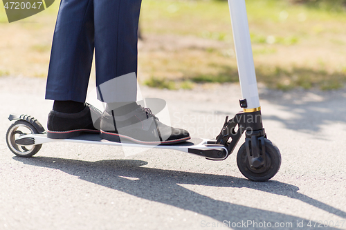 Image of young businessman with electric scooter outdoors