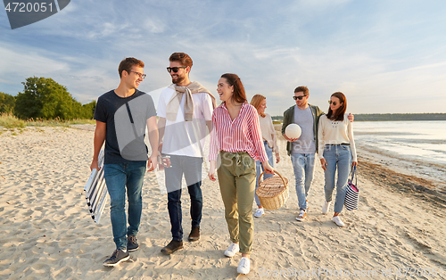 Image of happy friends walking along summer beach