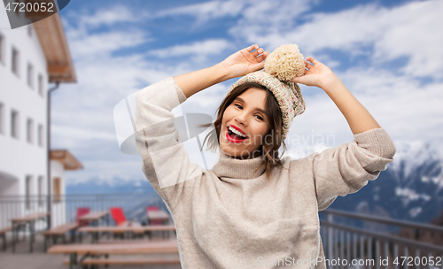 Image of woman in winter hat and sweater at ski resort