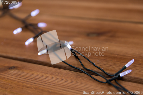 Image of christmas garland lights on wooden background