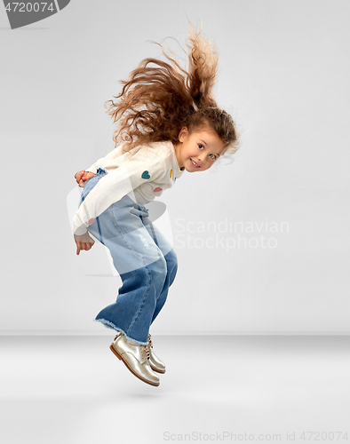 Image of smiling little girl jumping