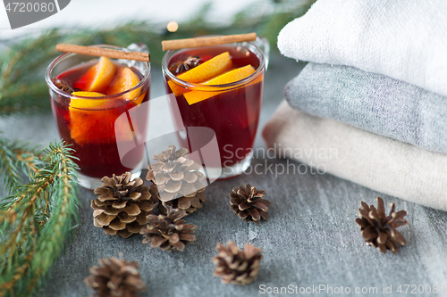 Image of mulled wine with orange and spices, cones and fir