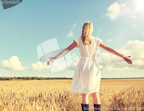 Image of happy young woman in white dress on cereal field