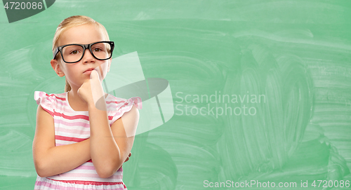 Image of cute little girl in glasses thinking at school