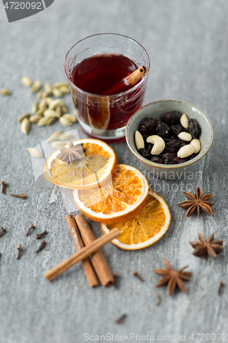 Image of hot mulled wine, orange slices, raisins and spices