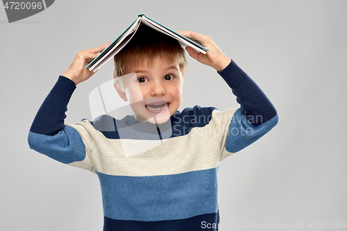 Image of little boy with roof of book on top of his head