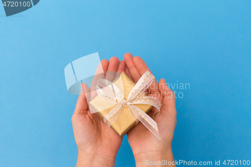 Image of hands holding small christmas gift box