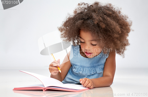 Image of happy little african american girl with sketchbook