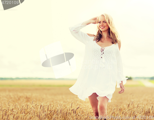 Image of smiling young woman in white dress on cereal field