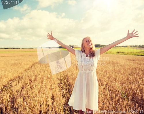 Image of smiling young woman in white dress on cereal field