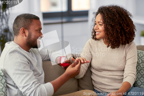 Image of african american man giving woman engagement ring