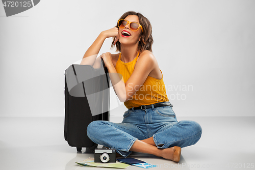 Image of woman with travel bag, air ticket, map and camera