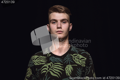 Image of Close up portrait of young man isolated on black studio background