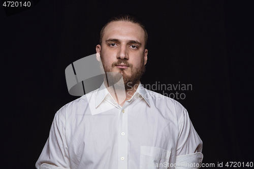 Image of Close up portrait of young man isolated on black studio background