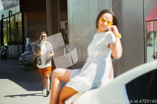 Image of Young couple preparing for vacation trip on the car in sunny day
