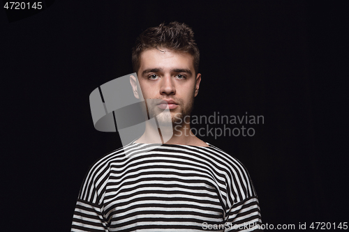 Image of Close up portrait of young man isolated on black studio background