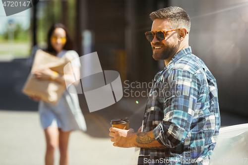 Image of Young couple preparing for vacation trip on the car in sunny day