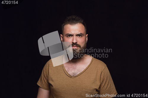 Image of Close up portrait of young man isolated on black studio background