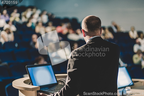 Image of Public speaker giving talk at business event.