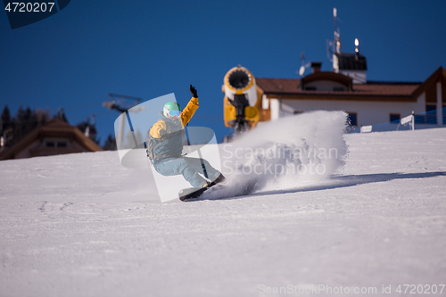 Image of snowboarder running down the slope and ride free style