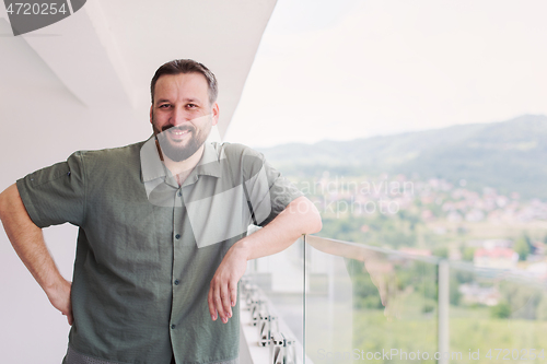 Image of man standing on a modern balcony