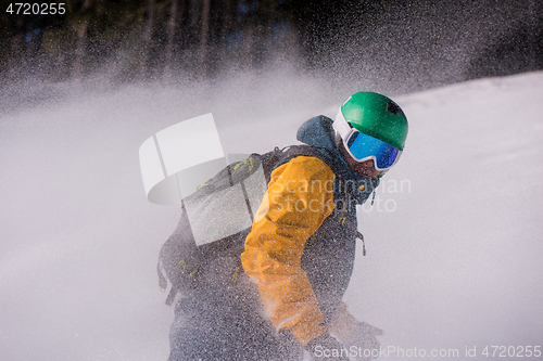 Image of snowboarder running down the slope and ride free style