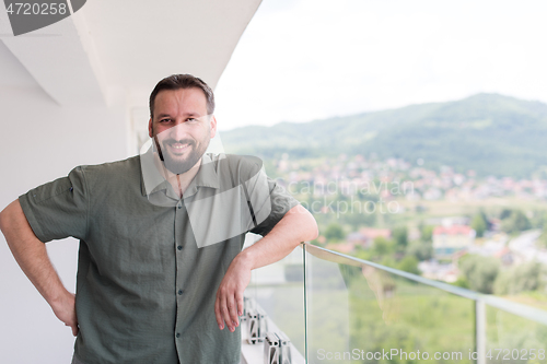 Image of man standing on a modern balcony