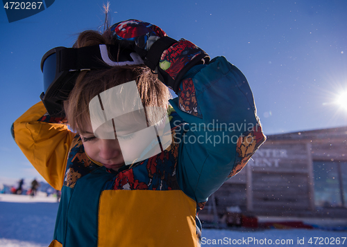 Image of little boy having a problem with ski goggles