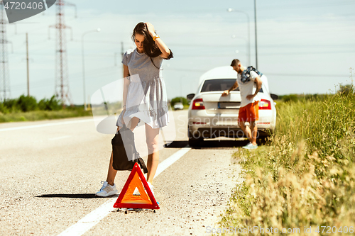 Image of Young couple traveling on the car in sunny day