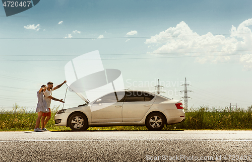 Image of Young couple traveling on the car in sunny day