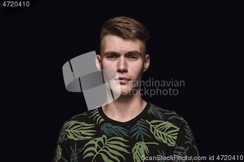 Image of Close up portrait of young man isolated on black studio background