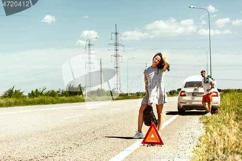 Image of Young couple traveling on the car in sunny day