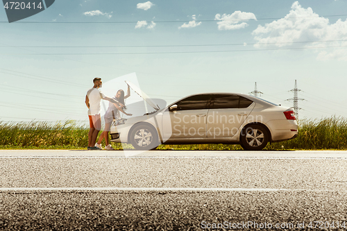 Image of Young couple traveling on the car in sunny day