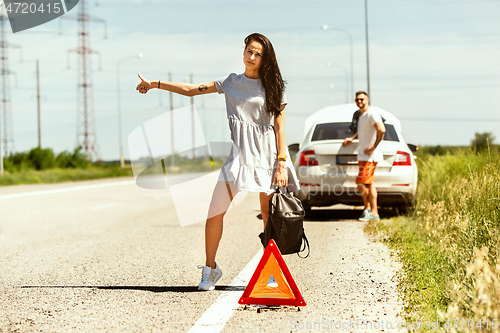 Image of Young couple traveling on the car in sunny day