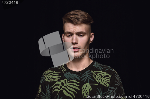 Image of Close up portrait of young man isolated on black studio background