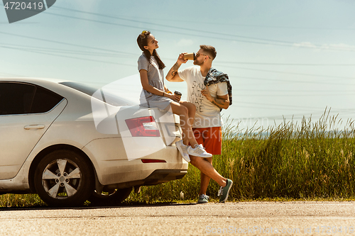 Image of Young couple traveling on the car in sunny day