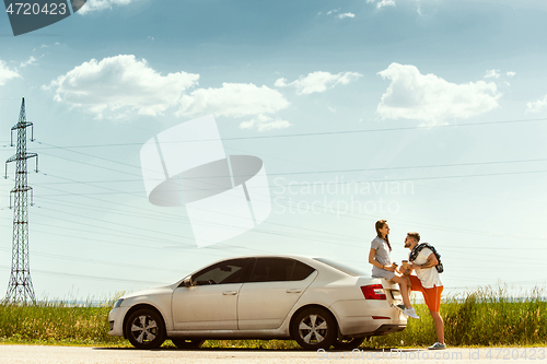 Image of Young couple traveling on the car in sunny day