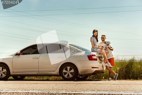 Image of Young couple traveling on the car in sunny day