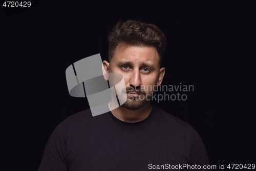 Image of Close up portrait of young man isolated on black studio background