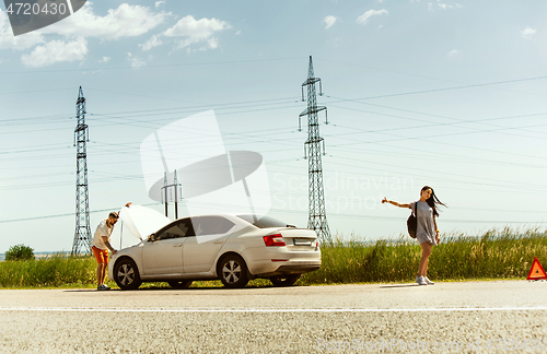 Image of Young couple traveling on the car in sunny day