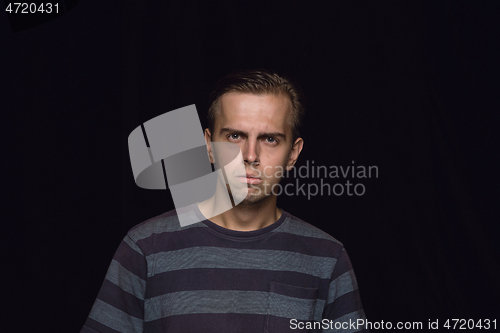 Image of Close up portrait of young man isolated on black studio background