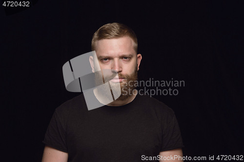 Image of Close up portrait of young man isolated on black studio background