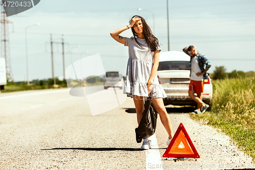 Image of Young couple traveling on the car in sunny day