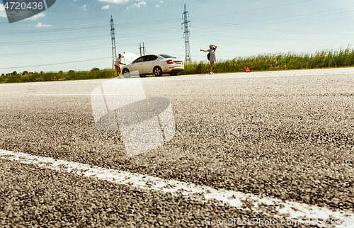 Image of Young couple traveling on the car in sunny day