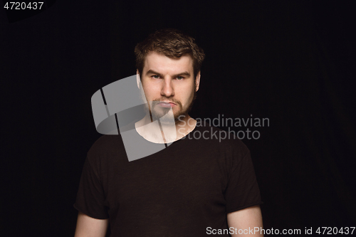 Image of Close up portrait of young man isolated on black studio background