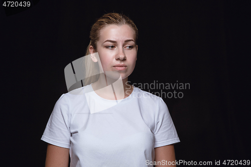 Image of Close up portrait of young woman isolated on black studio background